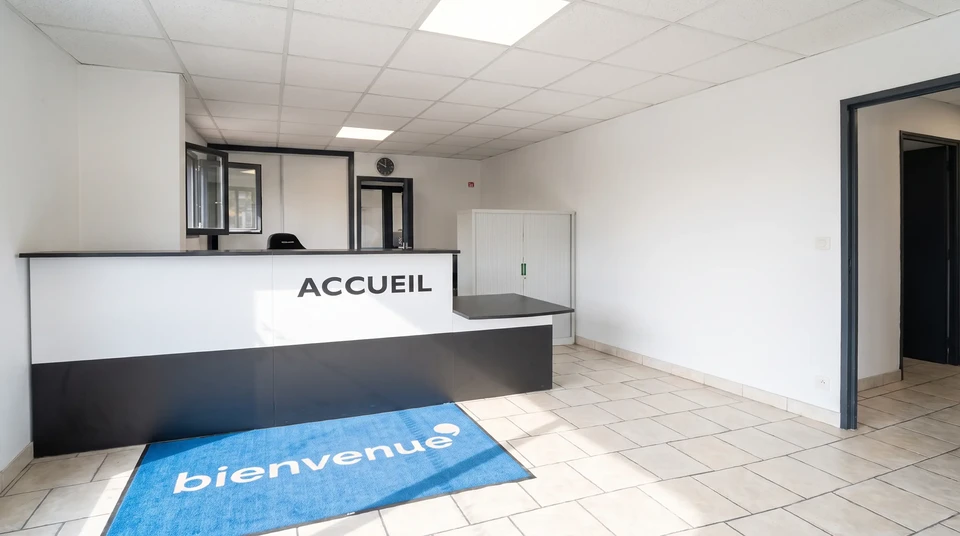 Accueil d'entreprise française, salle d'attente avec comptoir de réception blanc et noir portant l'inscription "ACCUEIL"